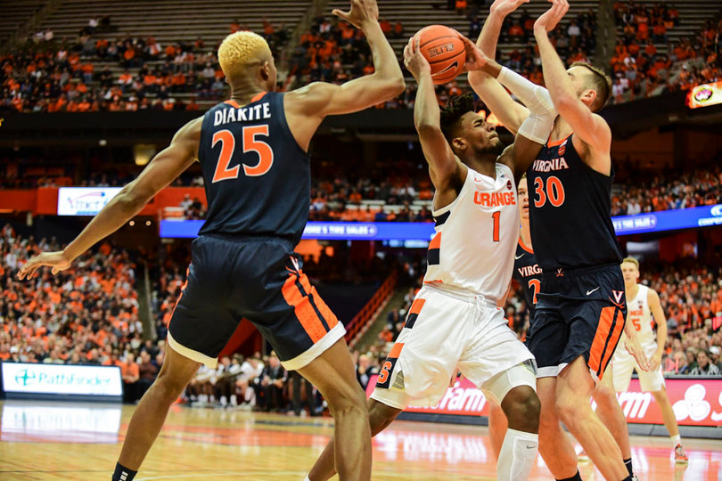 Quincy Guerrier takes on two UVA defenders in the paint