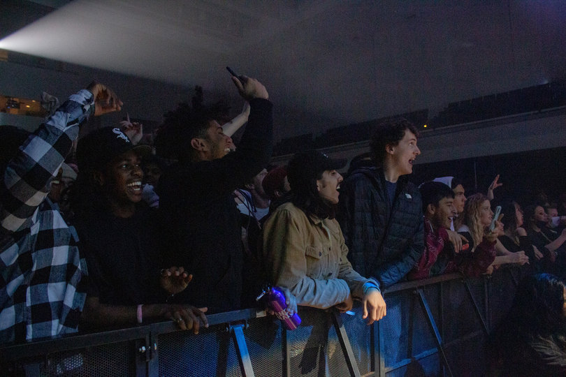 The front row of students jumps with the music as Zach Fox performs on the stage. 
