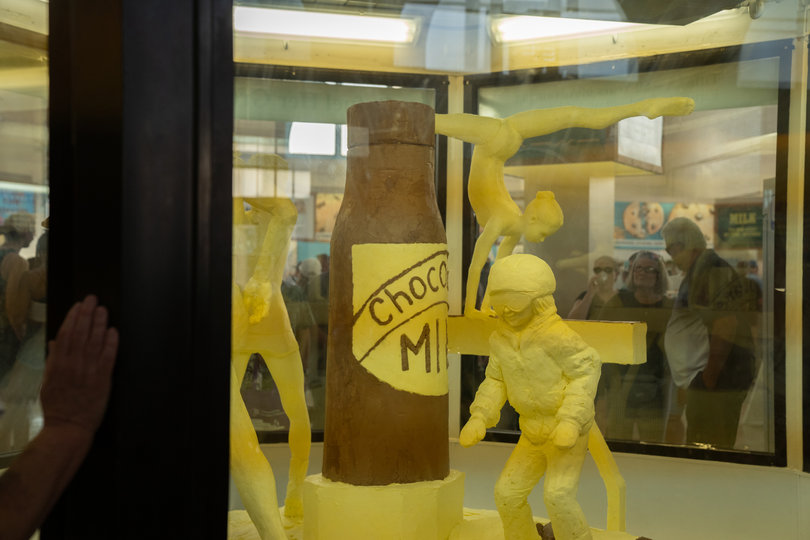 Onlookers gaze at "Refuel Her Greatness," the 2022 New York State Fair butter sculpture which celebrates the 50th anniversary of Title IX.