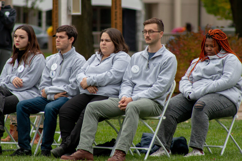 Remembrance Scholars Mackenzie Quinn, Ronald Ditchek, Mira Berenbaum, Adam Landry and Ofentse Mokoka sit in reflection on Shaw Quadrangle during the event. Some scholars wore pins with the face of the Pan Am Flight 103 victim they represent. 