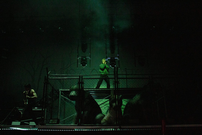 The Kid LAROI appears on stage amid a cloud of smoke and strobe lighting. The stage was set up to show three pit bulls in a cage where the rapper stood to open the show. 