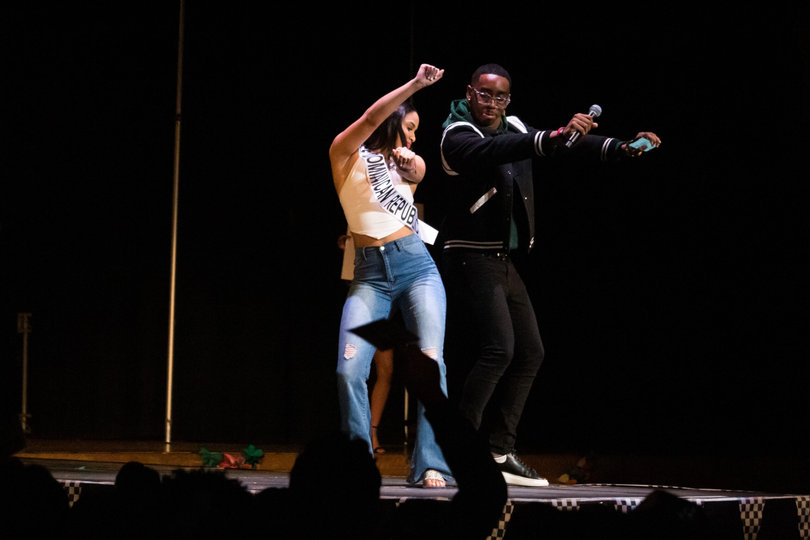 Dumervil and Honna Santos Lopez, a contestant representing the Dominican Republic, greet each other with a hip bump as she is introduced to the crowd. Dumervil welcomed each contestant to the stage with a different performative gesture. 