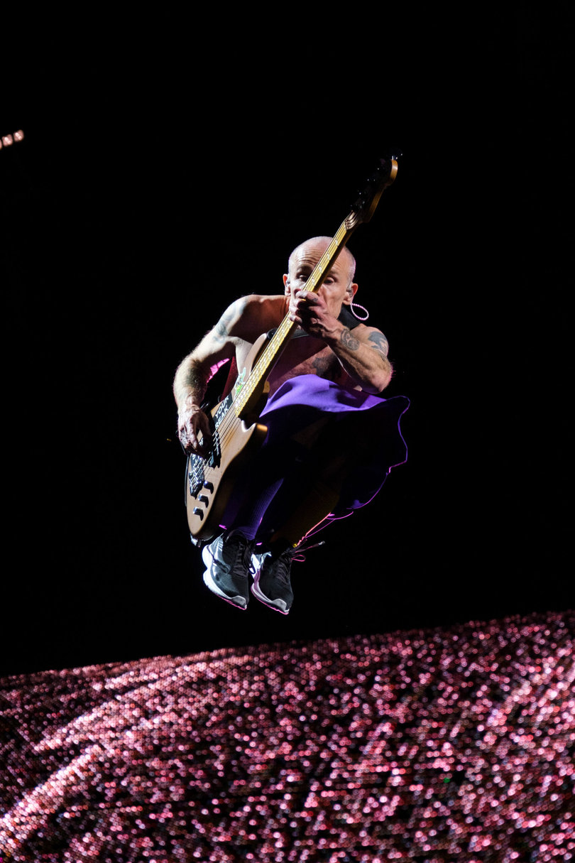 Red Hot Chili Peppers’ bassist Flea leaps in the air as the band performs. Spending the entire show shirtless, Flea jumped and moved around the stage.