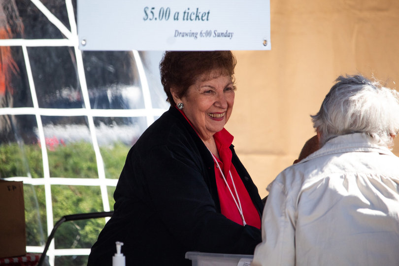 Festival founder Ginnie Lostumbo laughs with festival-goers while selling raffle tickets. Lostumbo said the people, attendees and volunteers are her favorite part of Festa Italiana.