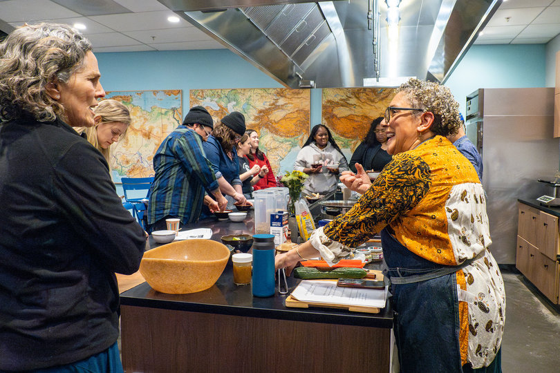 Naomi having a conversation with the students while cooking.
