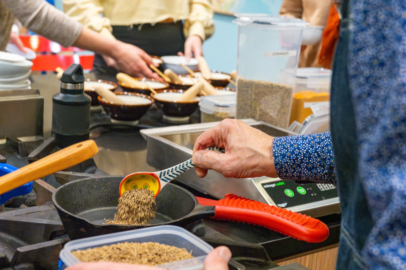Brian pouring spices into a pan.