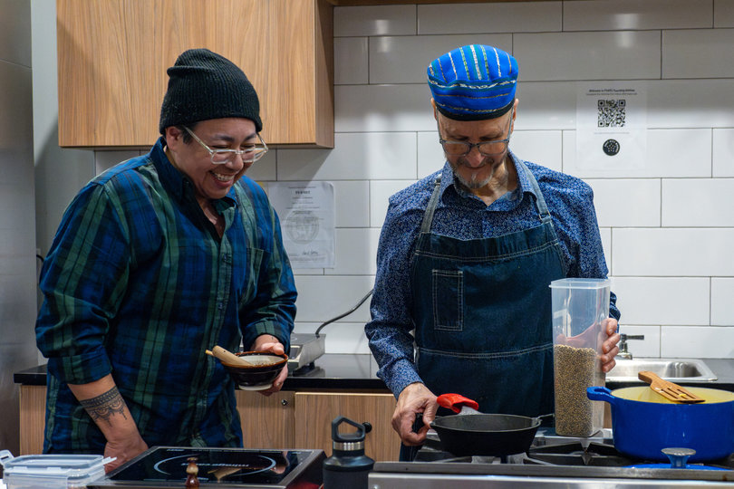 Brian cooking and laughing with a student.
