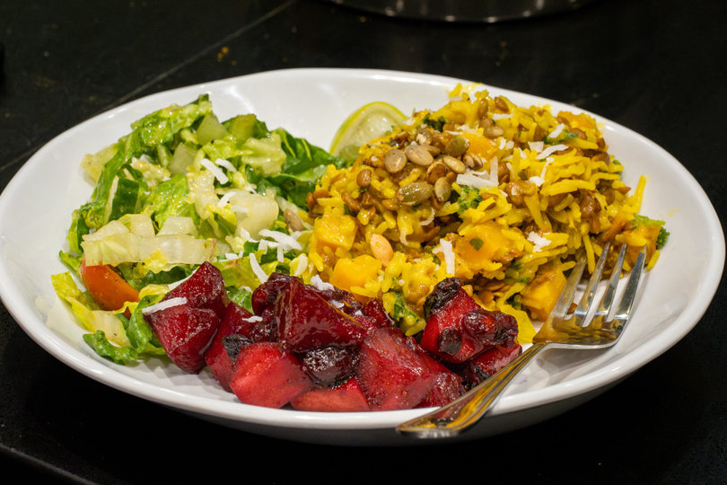 A dish with butternut squash kitchari, apple chutney and garden salad.