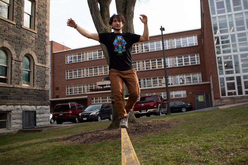 A student balances on a slackline.