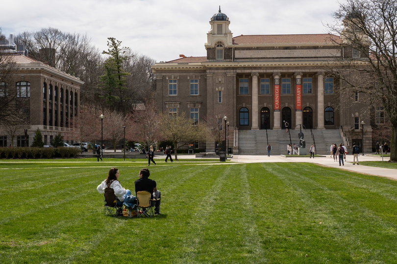 Two people sitting on a lawn.