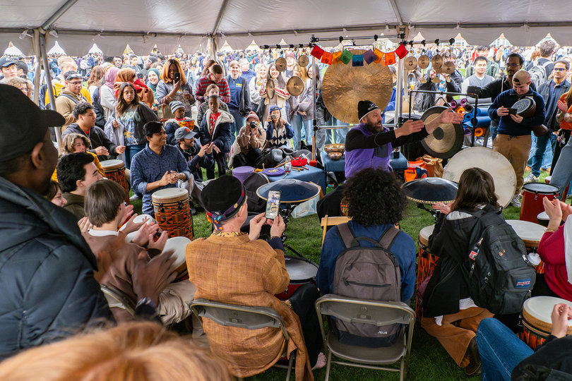 A crowd gathers to watch a drummer.