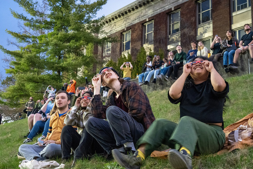 A group of people watch the sky.