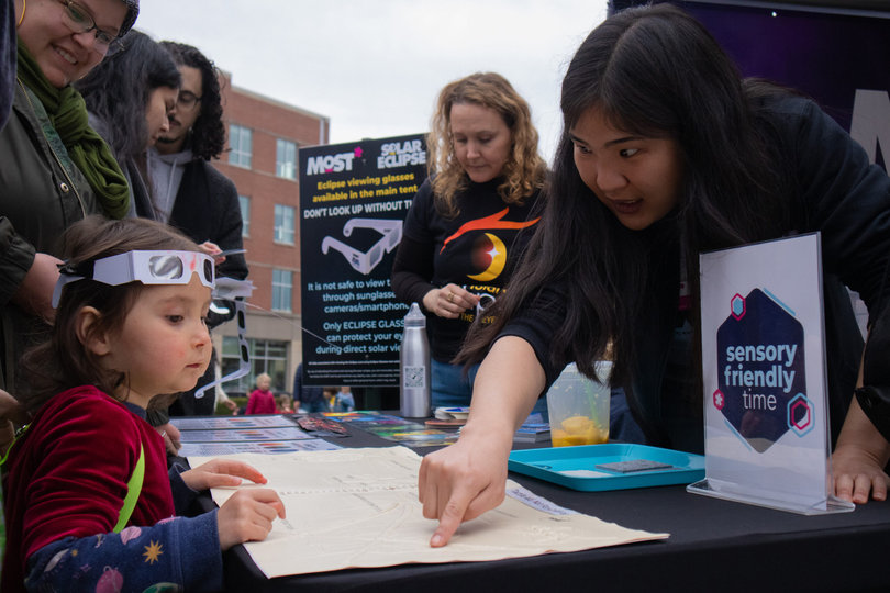 A woman showing a little girl a diagram.