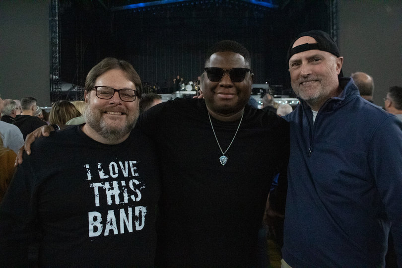 Three men smiling before the concert.