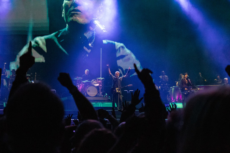 Wide shot of crowd with Springsteen on stage in the background