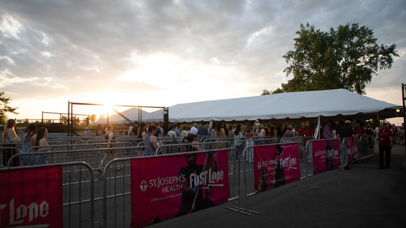 Fans line up at The Empower Federal Credit Union Amphitheater at Lakeview, Syracuse, as the sun sets. Hozier’s “Unreal Unearth” Tour kicked off the amphitheater's season. 
