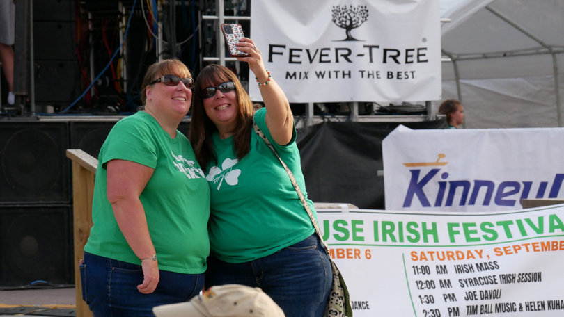 Two green-clad festival goers pose for a selfie in front of the Clonakilty Stage.