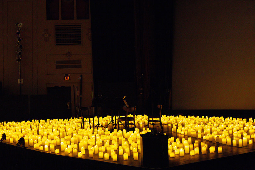 Candles fill the stage and provide soft, warm lighting to the Palace Theatre. 
