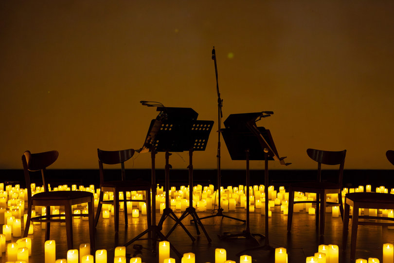 The Listeso String Quartet’s chairs and stands are set up amid a meadow of candles, giving the stage an ethereal glow.
