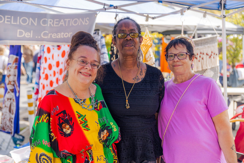 Delion Creations owners pose with a Westcott Street Cultural Fair attendee. The organization is one of 150 represented at the Fair.
