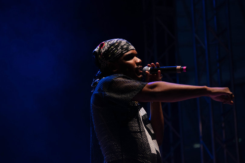 Illuminated by a spotlight, Smino points toward the crowd. Each artist actively engaged the audience in their own way.