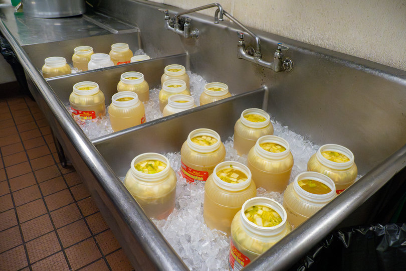 Pickles marinate chilled in ice in the basement of the Brooklyn Pickle. Pickles are included with every sandwich, with customers choosing between garlic or dill pickles.
