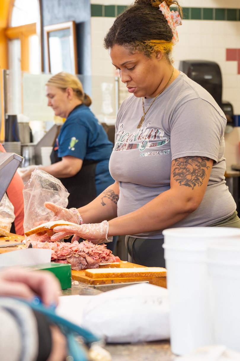 Employees make sandwiches for patrons during the lunch rush. Noon is the busiest time at the Brooklyn Pickle, and day staff have to be “all-star” caliber.
