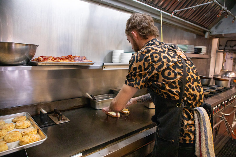 Gray prepares toast for customers. Tracy made the biscuits, a diner signature, that sit to Gray’s left. 
