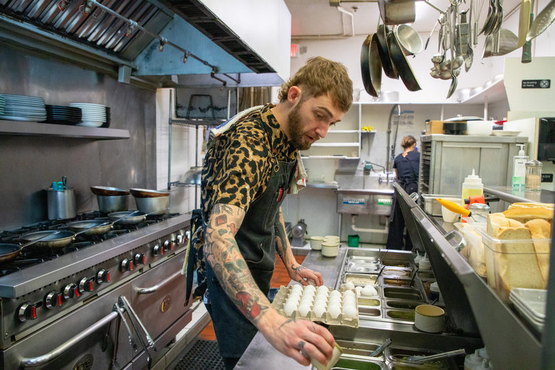 In the kitchen, Gray reaches for ingredients. After studying at culinary school, he wanted to open a diner that used fresh, locally-sourced ingredients.

