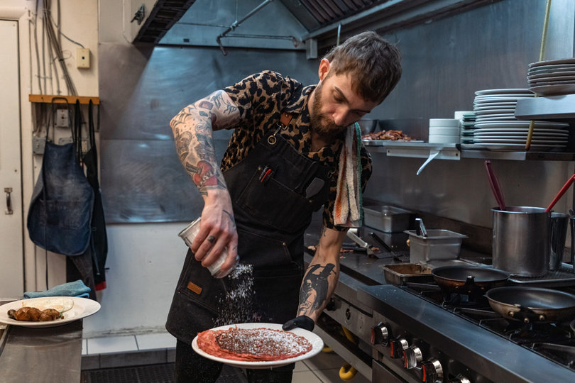 Gray Wessel sprinkles powdered sugar onto crunchberry pancakes for a finishing touch. Crunchberry pancakes are an On the Fly special.