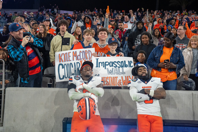 Syracuse defenders Marlowe Wax and Duce Chestnut pose with SU fans following the win over Washington State. Wax played his final game with the Orange while Chestnut has one year of eligibility remaining. 