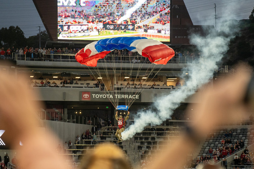 A paraglider flies in from the sky to land on the field pregame at the Holiday Bowl between Syracuse and Washington State in San Diego. As part of the Holiday Bowl, festivities included a helicopter flyover, halftime firework display and the pregame paragliders.