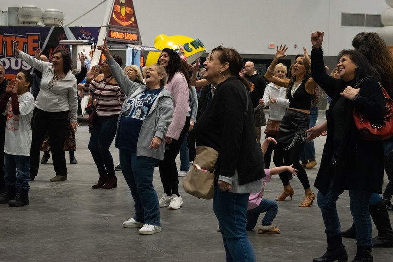 Attendees of all ages dance and sing along to RnB songs sung by the musical group ATLAS, from Rochester, New York.