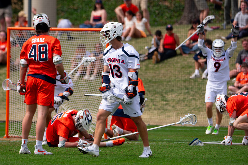 Virginia junior attack Ryan Colsey (No. 13) stares down Syracuse’s bench after scoring a lead-taking goal early in the fourth quarter, as Orange players fall to the ground in agony around him. Despite the setback, SU didn’t allow a goal for the final 11 minutes and 38 seconds of game time.