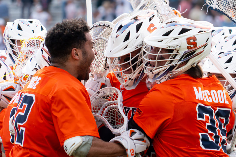 Short-stick midfielder Carter Rice (left, no helmet) mobs goalie Jimmy McCool (right) alongside other Syracuse teammates after its 12-10 triumph over Virginia Saturday in Charlottesville. McCool posted 17 saves and a .630 save percentage to guide the Orange to victory. 