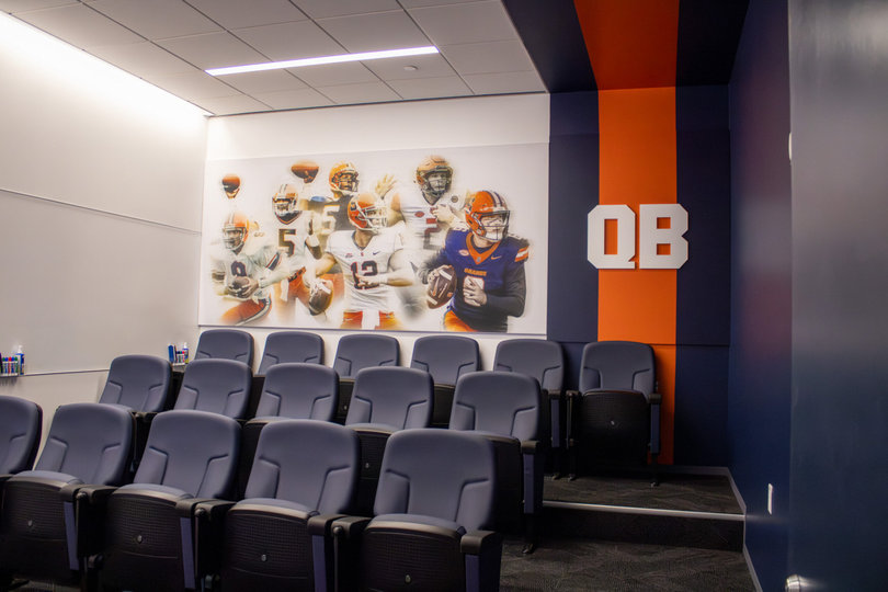 A look inside Syracuse’s new quarterbacks room, which features artwork of Kyle McCord (right), Eric Dungey (back-right), Ryan Nassib (middle), Donovan McNabb (back-left), Marvin Graves (middle-left) and Don McPherson (front-left).