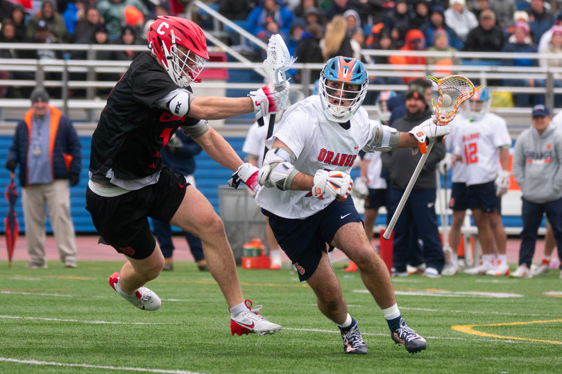 Syracuse midfield Michael Leo (right) looks to get past Cornell attack Michael Long and clear the ball. The Orange went 13-for-16 on clears, yet it wasn’t enough for them to leave Long Island with a win.