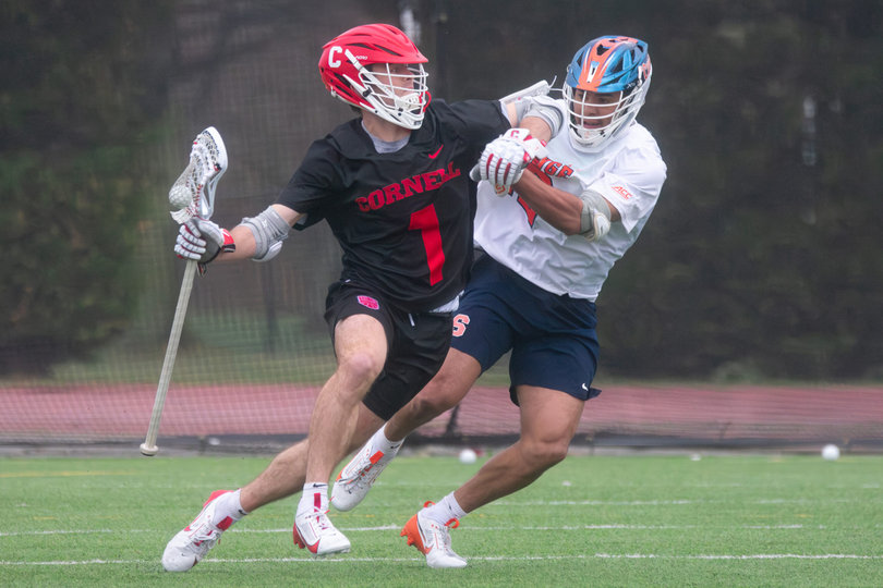 Cornell attack Michael Long (No. 1) cradles the ball driving at Syracuse short-stick midfielder Carter Rice (right). Long contributed one goal and two assists versus SU and was one of 10 Big Red players to get on the scoresheet.