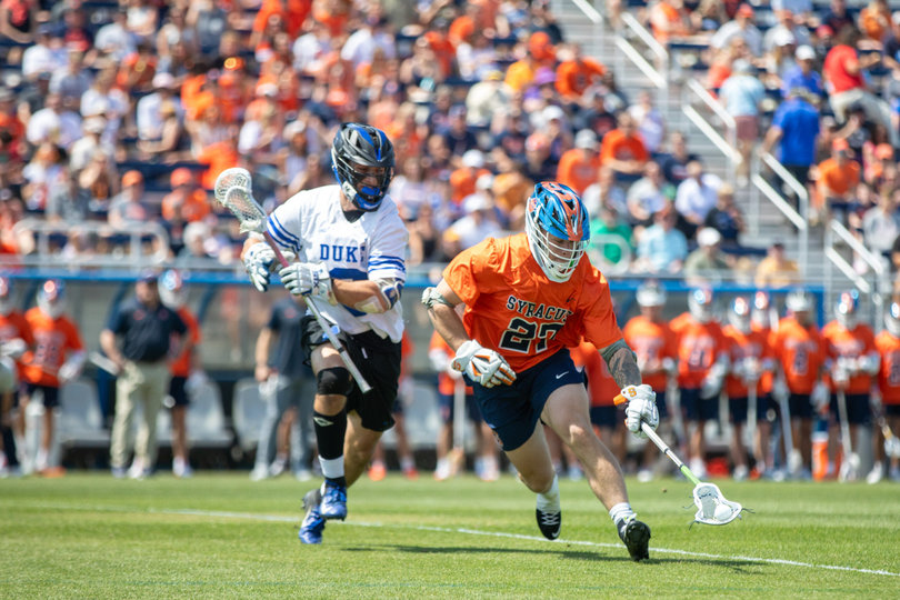 SU faceoff man John Mullen (No. 27) scoops up a ground ball against his counterpart Luke Engelke (No. 9). Mullen helped Syracuse win 12-of-22 faceoffs against Duke’s trio of Cal Girard, Engelke and Ben McCarthy.