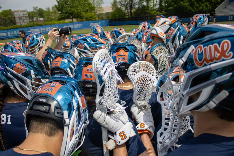 Syracuse converges to conduct a huddle. The ‘HHH’ on the back of the Orange’s helmets stands for Head, Heart, Hustle — a motto symbolizing the team’s ethos.
