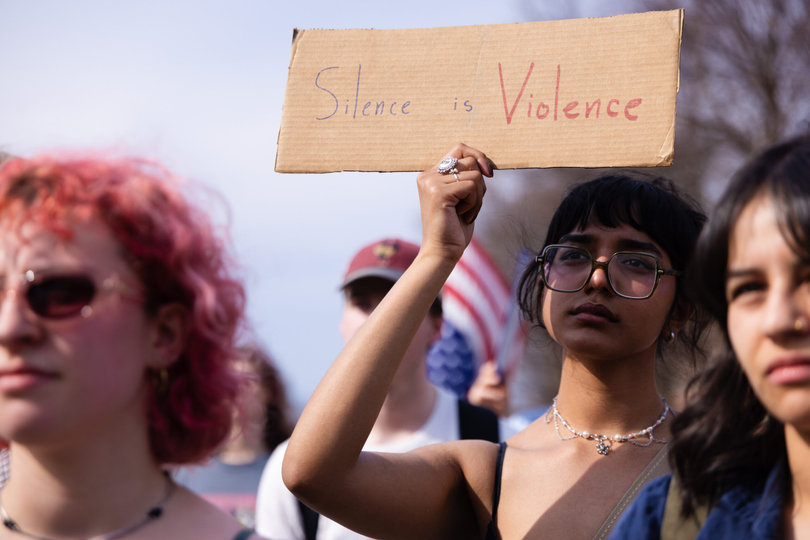 A protester raises a sign condemning silence. Protesters emphasized the importance of collaborating and continuing to fight back.