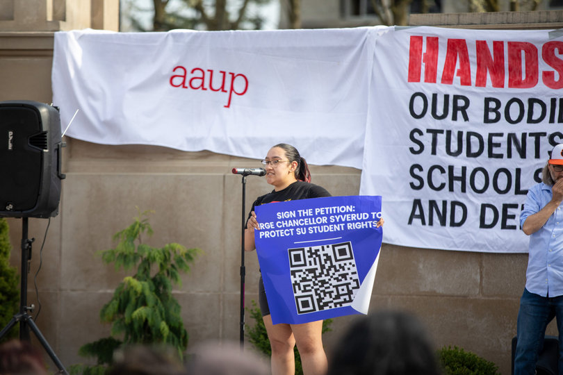 A speaker at the protest encourages attendees to sign a petition. Syracuse University Chancellor Kent Syverud was not among the more than 200 university leaders who signed a Tuesday open letter condemning President Donald Trump.