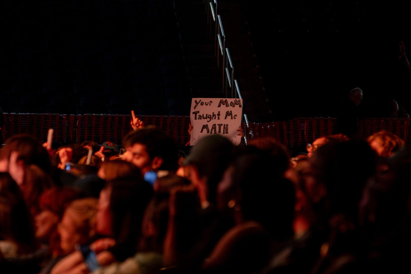 A student holds up a sign reading “Your Mom Taught Me Math” during Role Model’s performance. Role Model said he would tell his mother, a teacher, about the sign. 