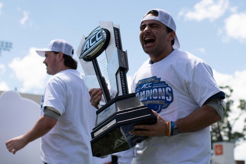 Paul Lamonaca celebrates with the ACC Tournament trophy after SU’s 9-8 win over Duke. The Orange upset No. 1 Notre Dame before defeating Duke to claim the title.