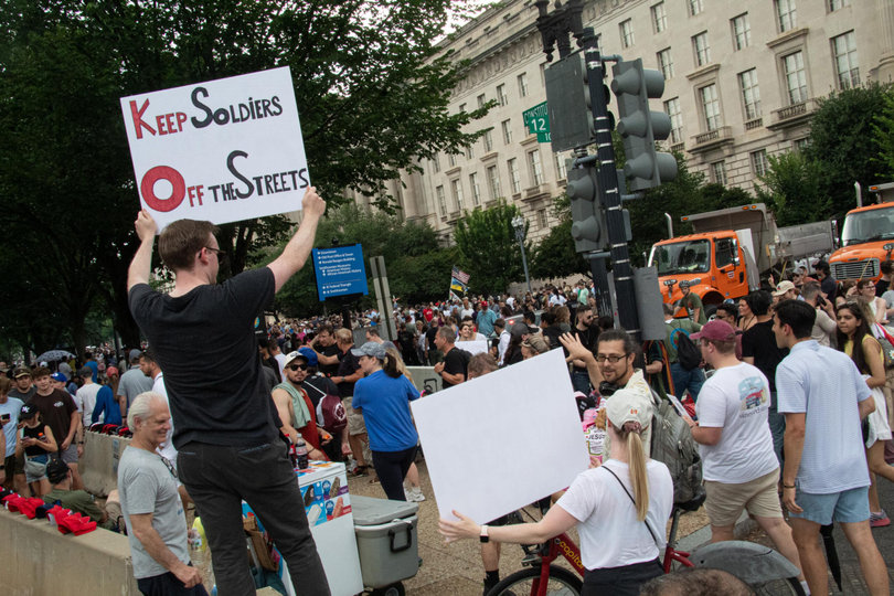 WASHINGTON, D.C. — Thousands of people flood Constitution Avenue, standing in line to enter the U.S. Army 250th Birthday Parade. Demonstrators walk through the crowds, spreading their messages through posters.