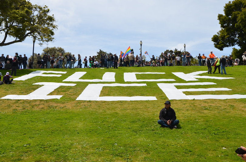 SAN FRANCISCO, CA —  A man sits in front of a “F*CK ICE” sign on the grass of Dolores Park. While the “No Kings” protests had been planned for five weeks, Liliana Soroceanu, Indivisible SF’s media liaison, said the deployment of military to anti-Immigration and Customs Enforcement protests in LA increased urgency for the demonstrations.