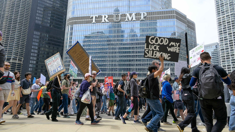 CHICAGO, IL — Protesters yelled “shame” as they marched past Trump International Hotel and Tower Chicago. “No Kings” motto declared: “The corruption has gone too. far. No thrones. No crowns. No kings.”
