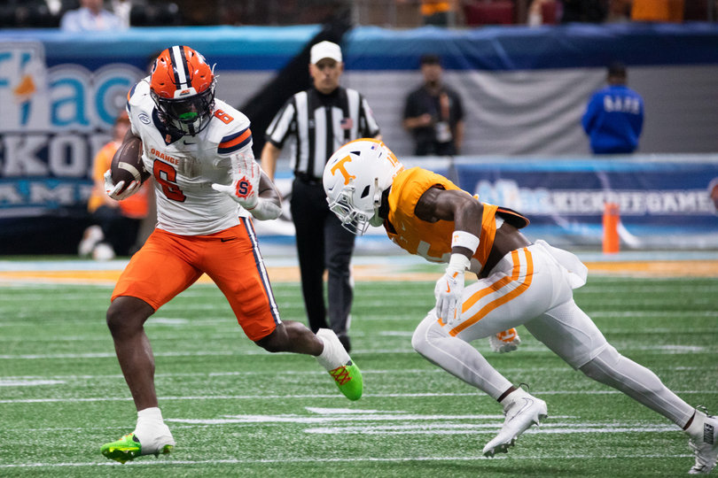 Syracuse running back Yasin Willis prepares to stiff arm Tennessee defensive back Edrees Farooq. Willis led the Orange with three rushing touchdowns against the Volunteers.