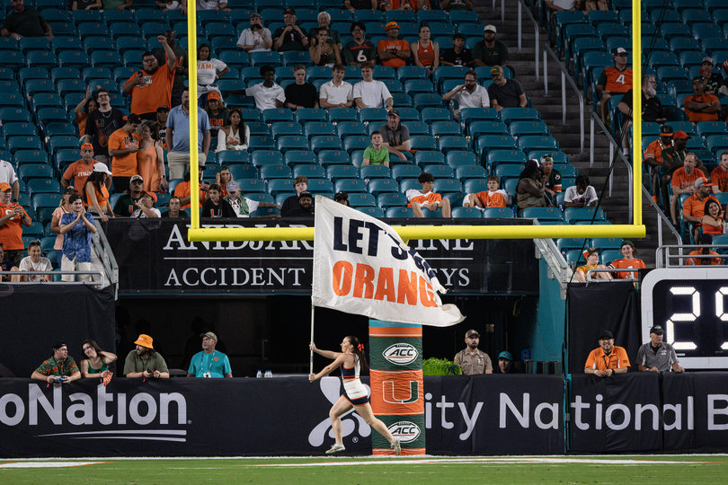 A Syracuse cheerleader sprints across the endzone, holding a “Let’s Go Orange” banner. Miami found the end zone five separate times in its 38-10 victory over Syracuse Saturday.
