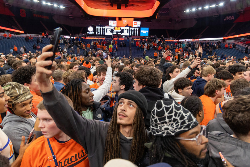Syracuse fans pack together on the JMA Wireless Dome court after storming it following SU’s top-15 win. The victory moved the Orange to 5-3 on the season, nearly halfway to their 14 total wins last season.